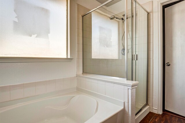 bathroom with hardwood / wood-style floors and independent shower and bath