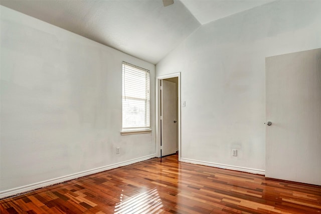 empty room featuring hardwood / wood-style floors and lofted ceiling