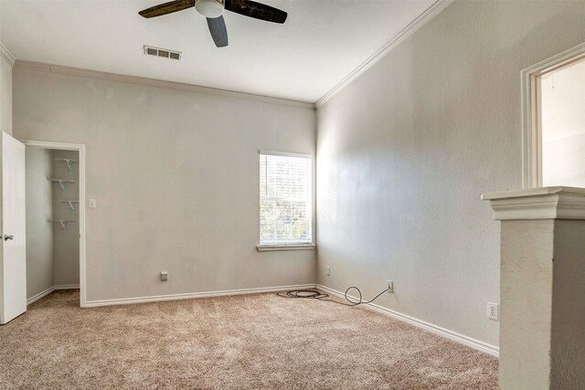 spare room featuring light colored carpet, ceiling fan, and ornamental molding