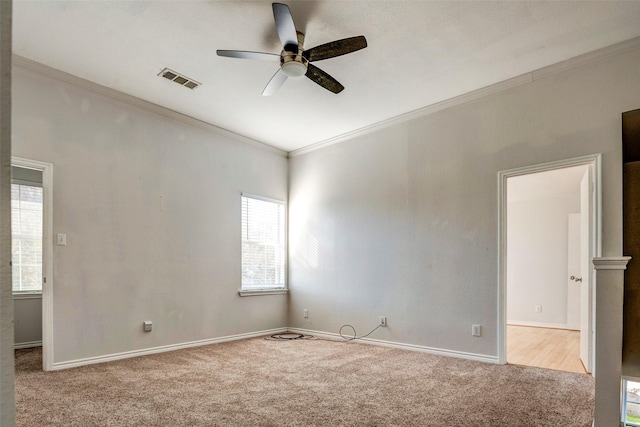 carpeted spare room featuring ceiling fan and ornamental molding