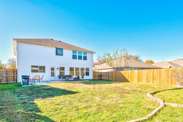 back of property with a yard and a patio