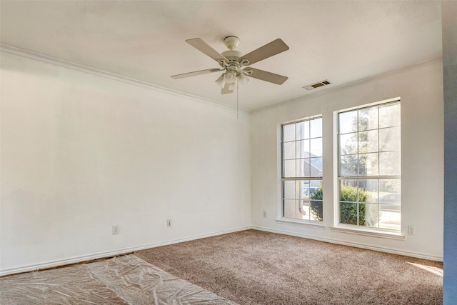 carpeted spare room featuring ceiling fan and ornamental molding