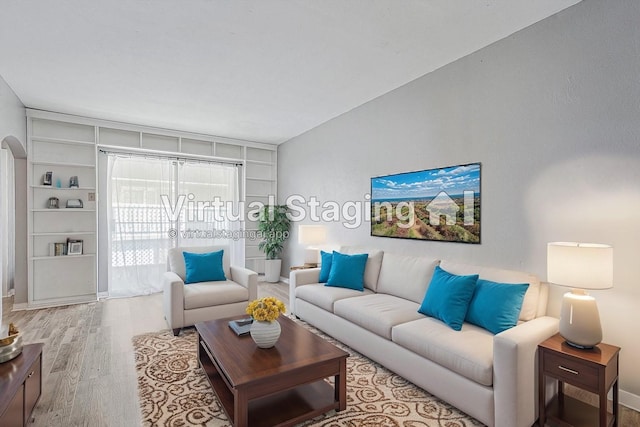 living area with arched walkways and wood finished floors