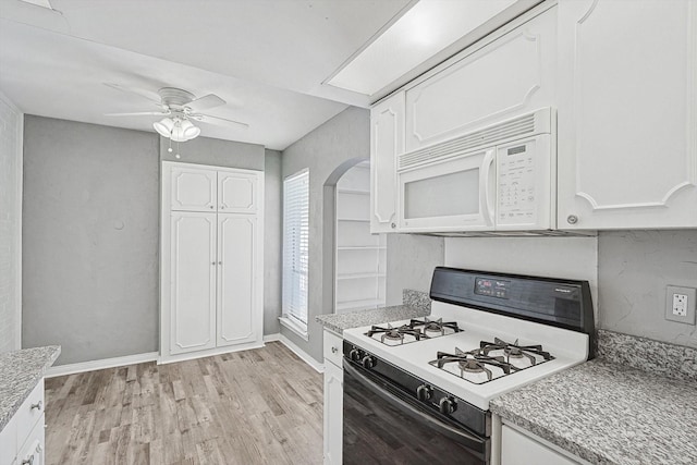 kitchen featuring arched walkways, white appliances, and white cabinets