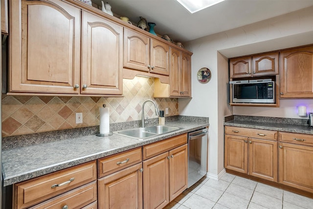 kitchen featuring stainless steel appliances, light tile patterned flooring, backsplash, and sink