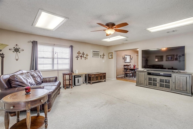 carpeted living room with ceiling fan, a wall mounted AC, and a textured ceiling