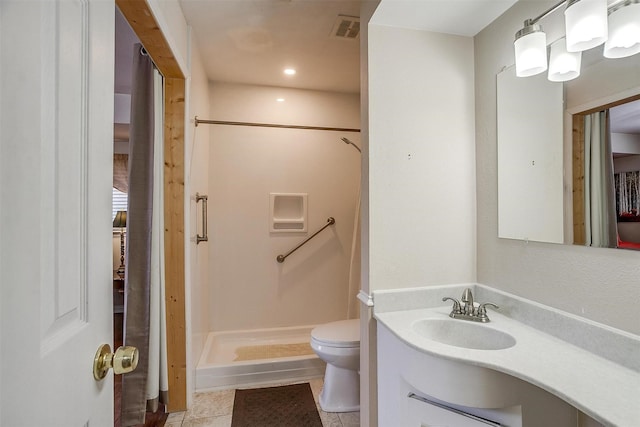 bathroom featuring toilet, tile patterned floors, walk in shower, and vanity