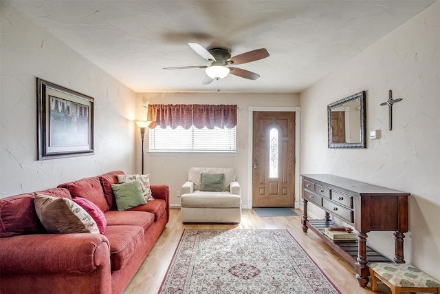 living room with light hardwood / wood-style floors and ceiling fan