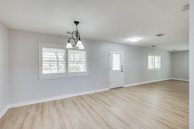 interior space with light hardwood / wood-style floors and an inviting chandelier