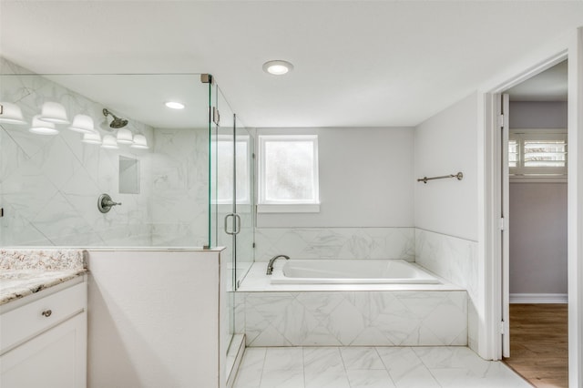 bathroom with shower with separate bathtub, vanity, and a wealth of natural light