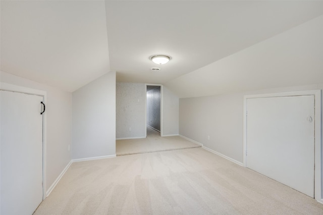 bonus room featuring lofted ceiling and light carpet