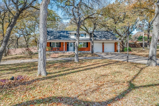 view of front of property featuring covered porch, a garage, and a front lawn