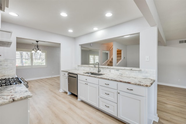 kitchen featuring tasteful backsplash, white cabinetry, sink, and light stone counters