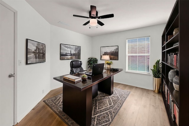 home office with hardwood / wood-style flooring and ceiling fan