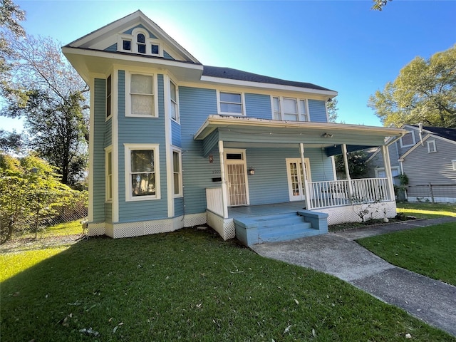 view of front of home with covered porch and a front lawn