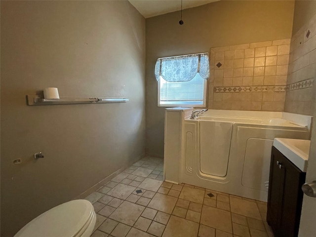 bathroom with vanity, tile patterned flooring, a tub, and toilet