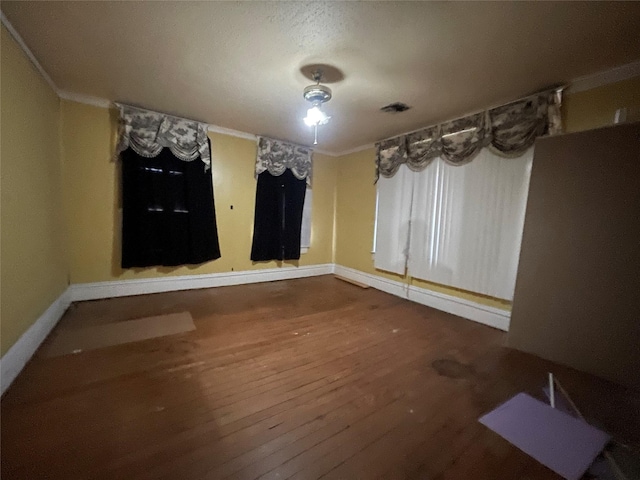 unfurnished room featuring hardwood / wood-style floors and crown molding