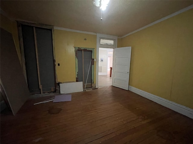 unfurnished room featuring hardwood / wood-style floors and crown molding