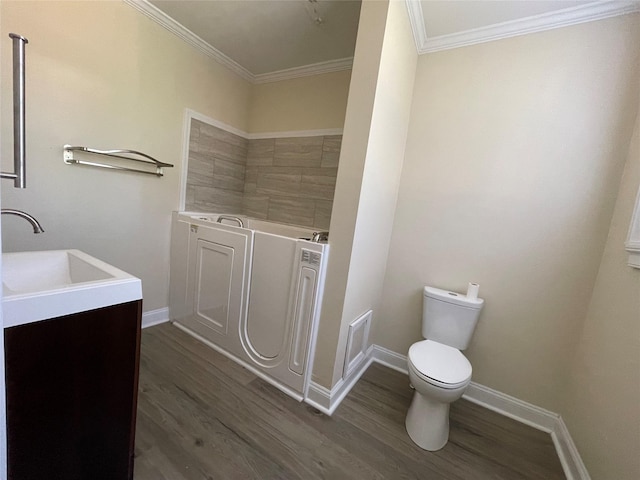 bathroom with a tub, vanity, wood-type flooring, and ornamental molding