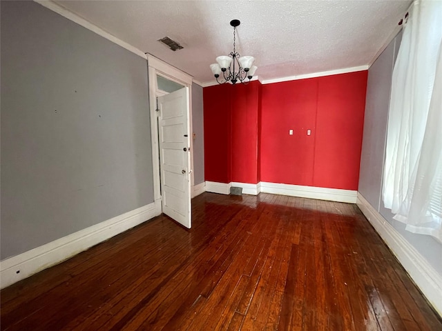 unfurnished dining area featuring a textured ceiling, dark hardwood / wood-style flooring, ornamental molding, and a notable chandelier