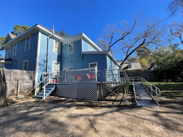 rear view of property featuring a wooden deck