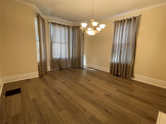 unfurnished room featuring dark hardwood / wood-style flooring, an inviting chandelier, and crown molding