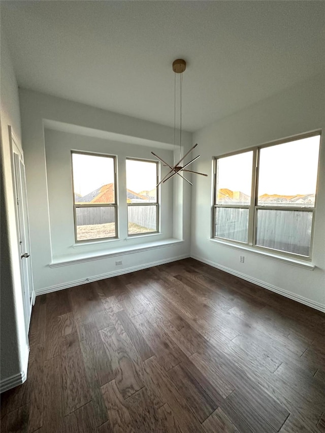 unfurnished dining area featuring dark hardwood / wood-style floors and a notable chandelier