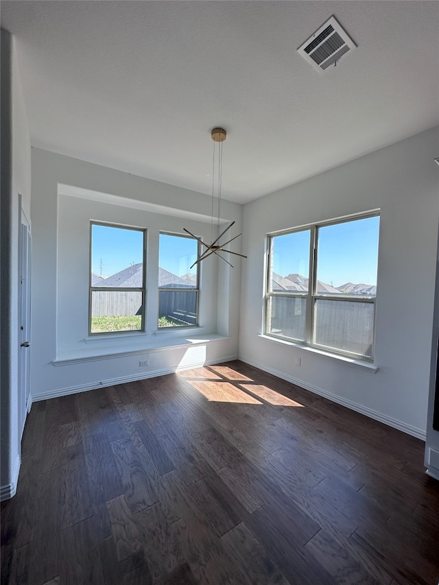 interior space featuring a mountain view, dark hardwood / wood-style flooring, an inviting chandelier, and a healthy amount of sunlight