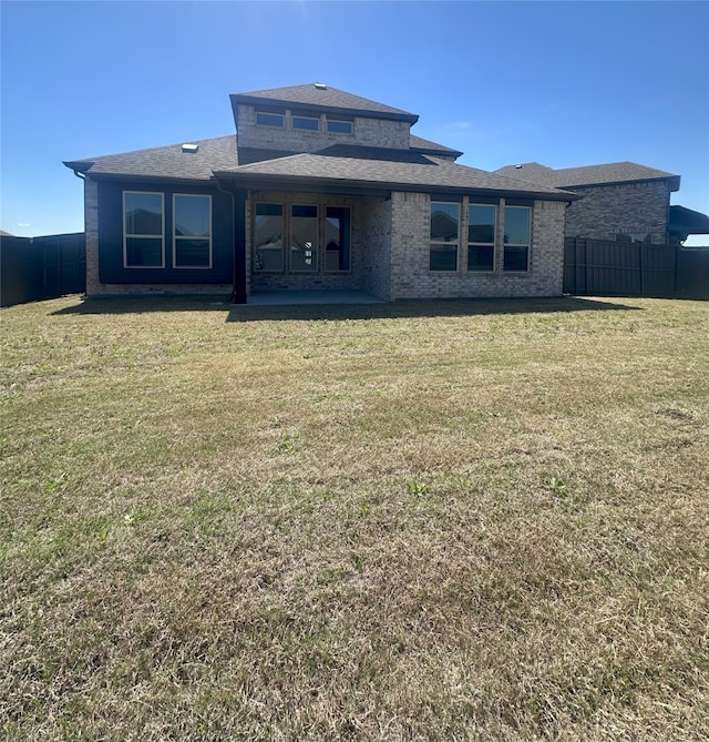 back of property featuring a lawn