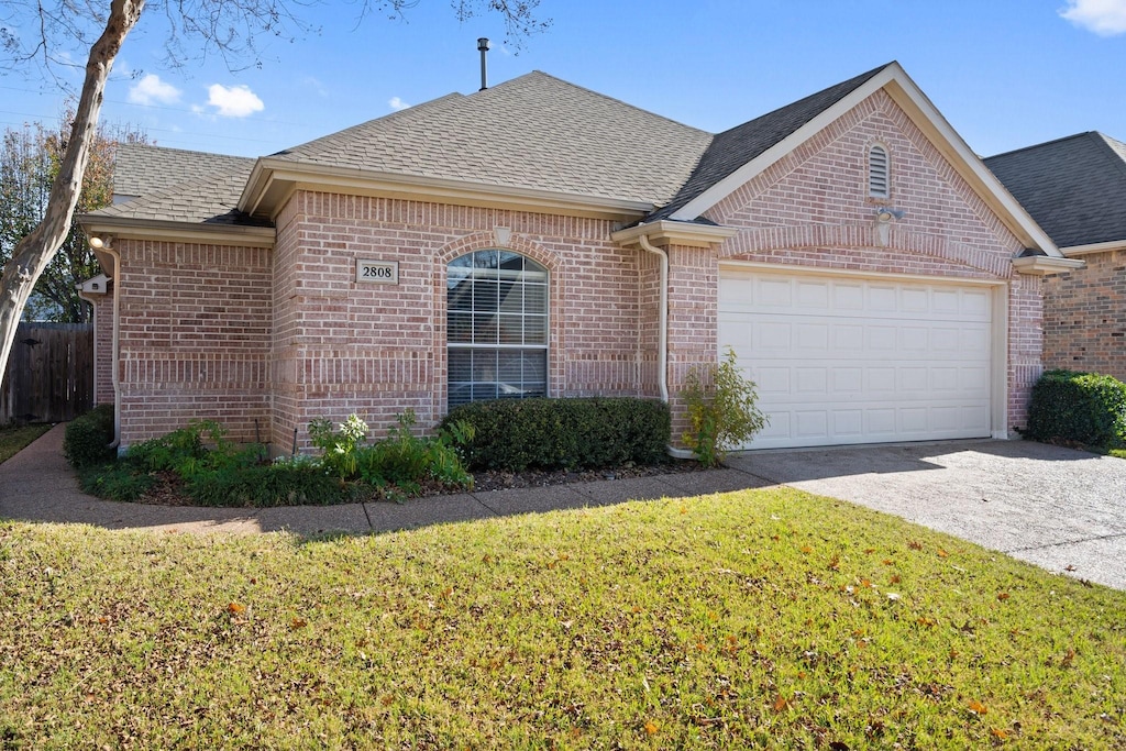 single story home featuring a garage and a front yard