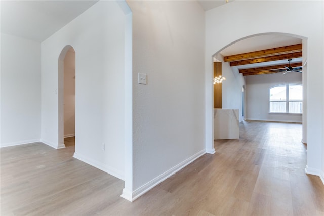 corridor with beamed ceiling and light hardwood / wood-style flooring