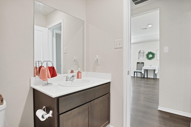 bathroom with hardwood / wood-style flooring, toilet, and vanity