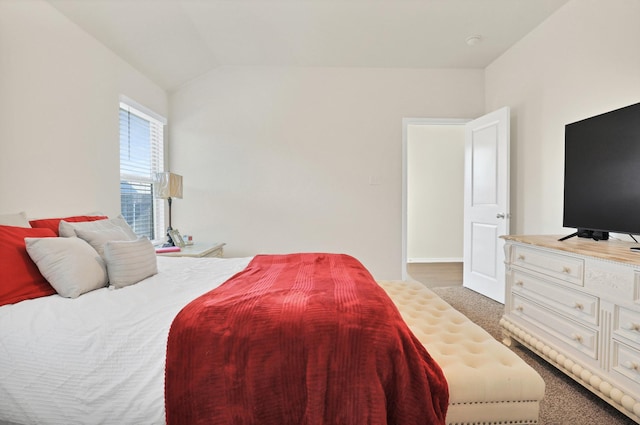 bedroom with lofted ceiling and dark carpet