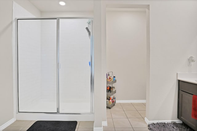 bathroom with a shower with shower door, tile patterned floors, and vanity