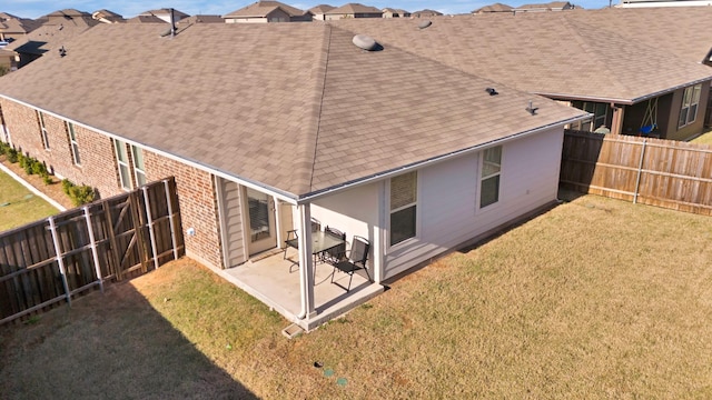 rear view of house with a lawn and a patio