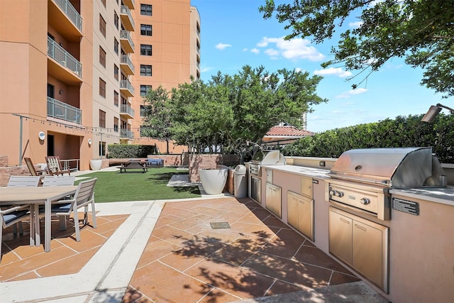 view of patio featuring an outdoor kitchen and a grill