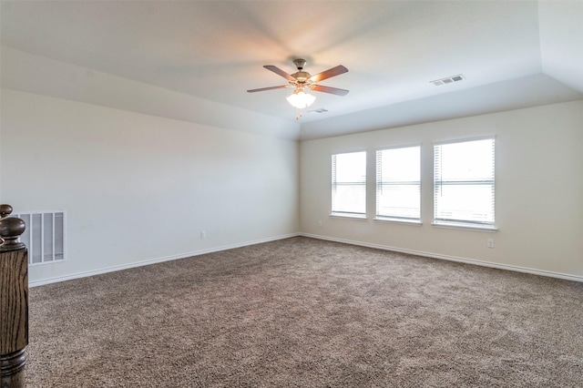 carpeted spare room featuring ceiling fan and vaulted ceiling