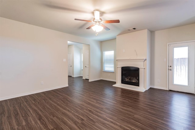 unfurnished living room with dark hardwood / wood-style flooring and ceiling fan