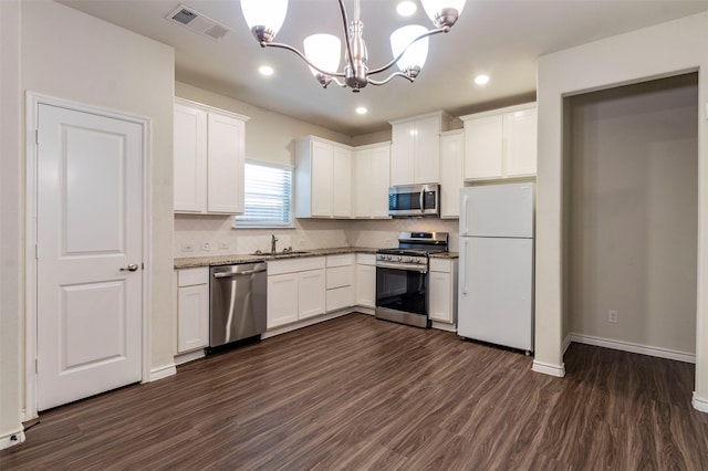 kitchen with white cabinets, stainless steel appliances, hanging light fixtures, and dark hardwood / wood-style floors