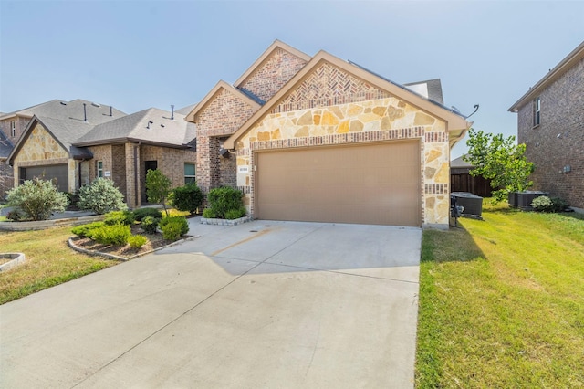 view of front of house with a front yard, a garage, and central air condition unit