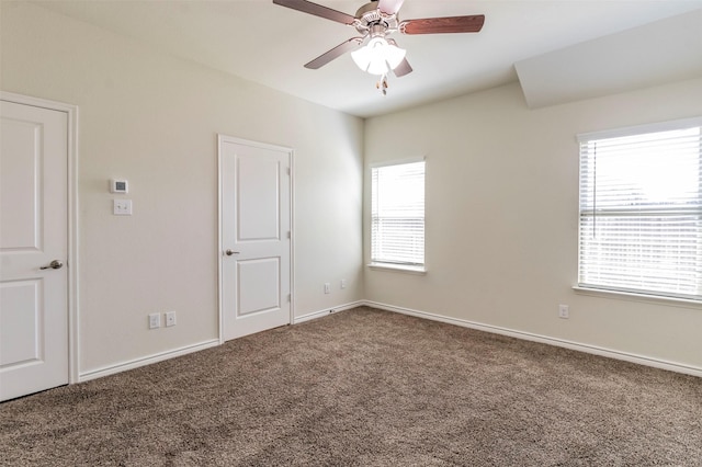 carpeted spare room with plenty of natural light and ceiling fan