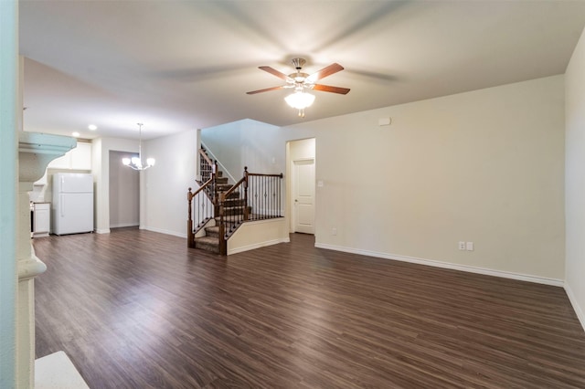 unfurnished living room with ceiling fan with notable chandelier and dark wood-type flooring