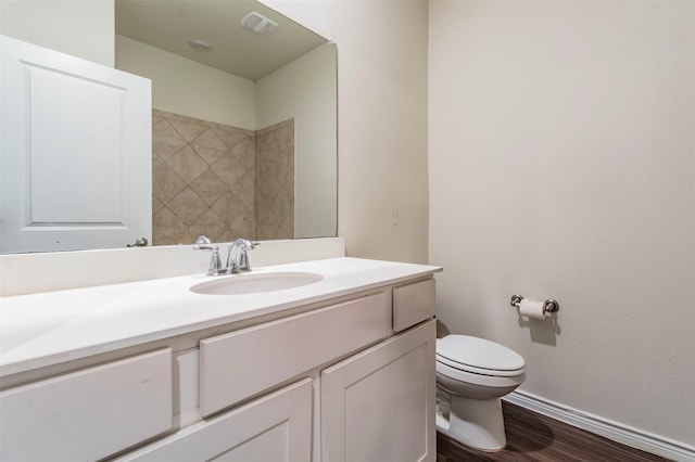 bathroom with hardwood / wood-style flooring, vanity, and toilet