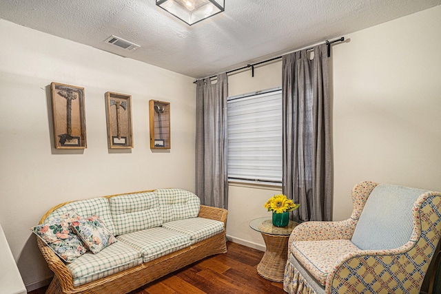 sitting room featuring dark hardwood / wood-style floors and a textured ceiling