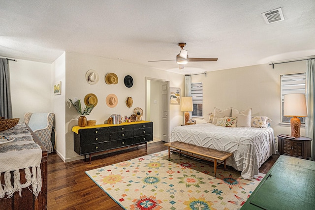 bedroom with dark hardwood / wood-style flooring, ceiling fan, and a textured ceiling