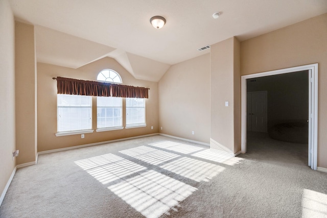 carpeted spare room with lofted ceiling