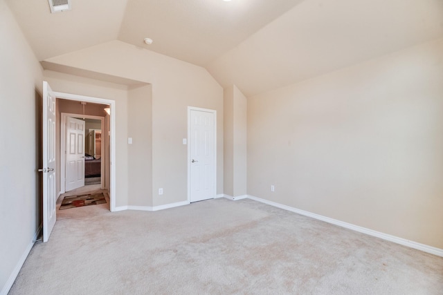 unfurnished bedroom featuring light colored carpet and lofted ceiling