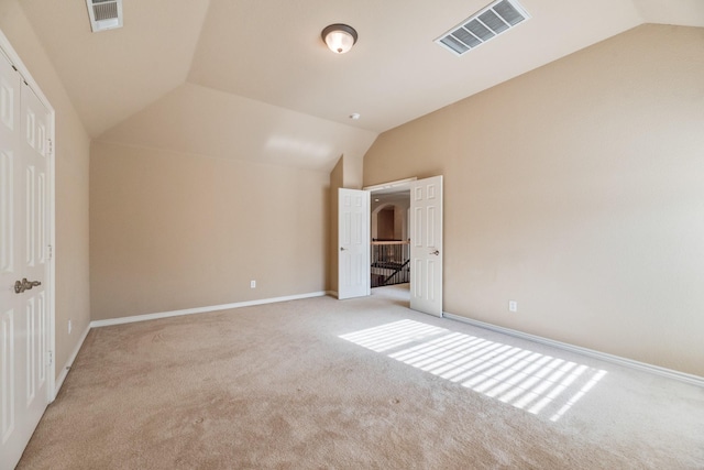 unfurnished bedroom with light carpet and lofted ceiling