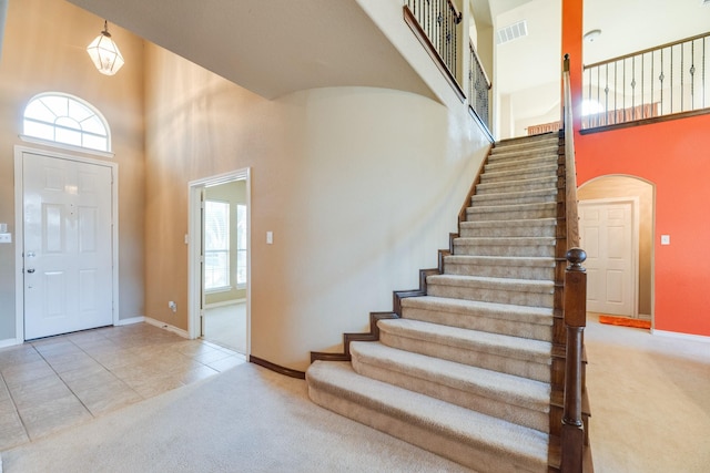 entrance foyer featuring tile patterned flooring and a towering ceiling