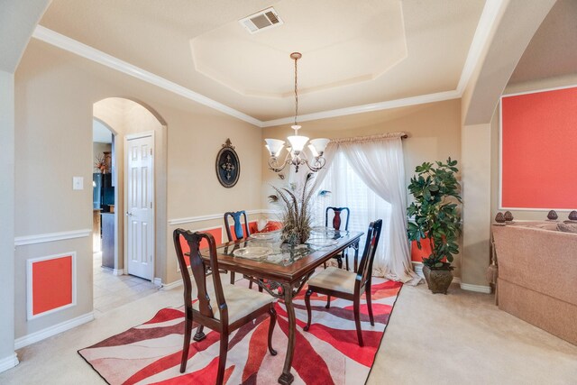 dining room with a raised ceiling, light colored carpet, crown molding, and a chandelier